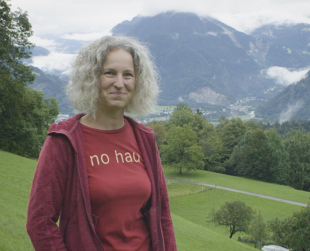 Porträt Tanja Moser Tanja Moser steht auf einer Wiese vor einer alpinen Landschaft
